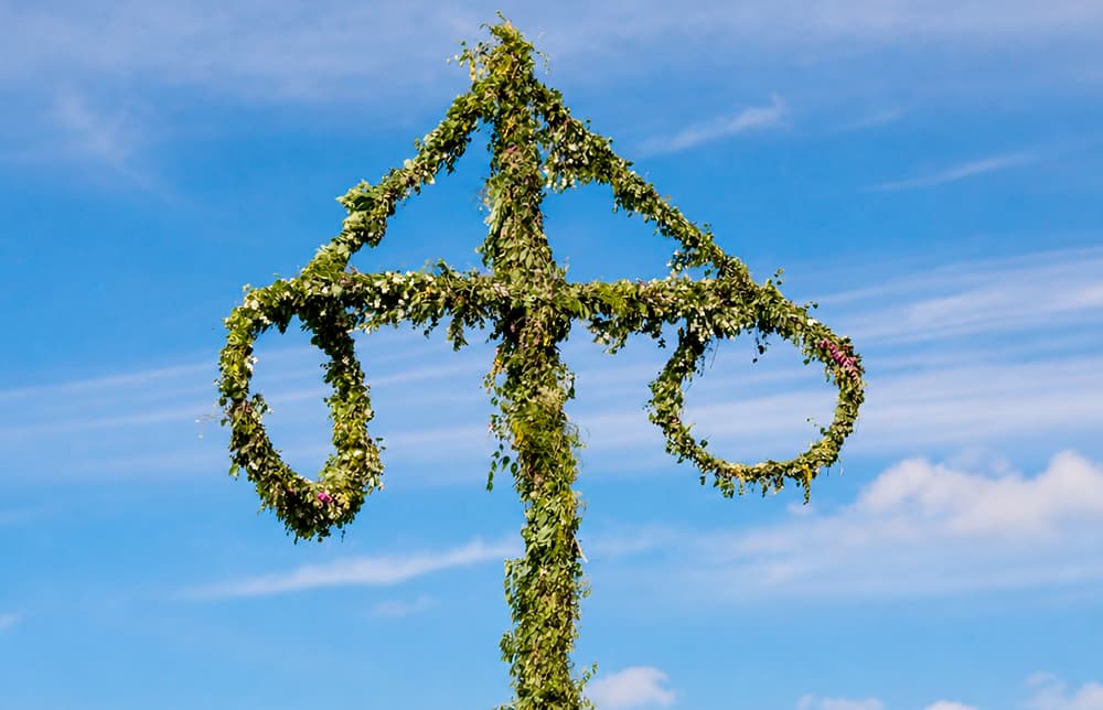 Midsommarstång decorated with flowers and green garlands ready for Midsommar in Stockholm